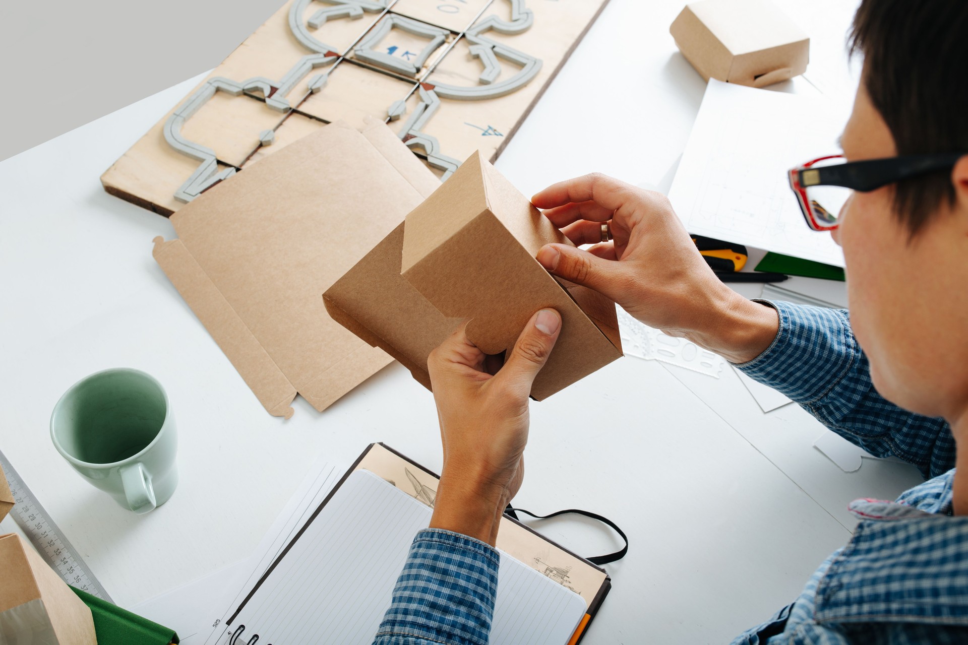 Young box designer looking at the folding of the product