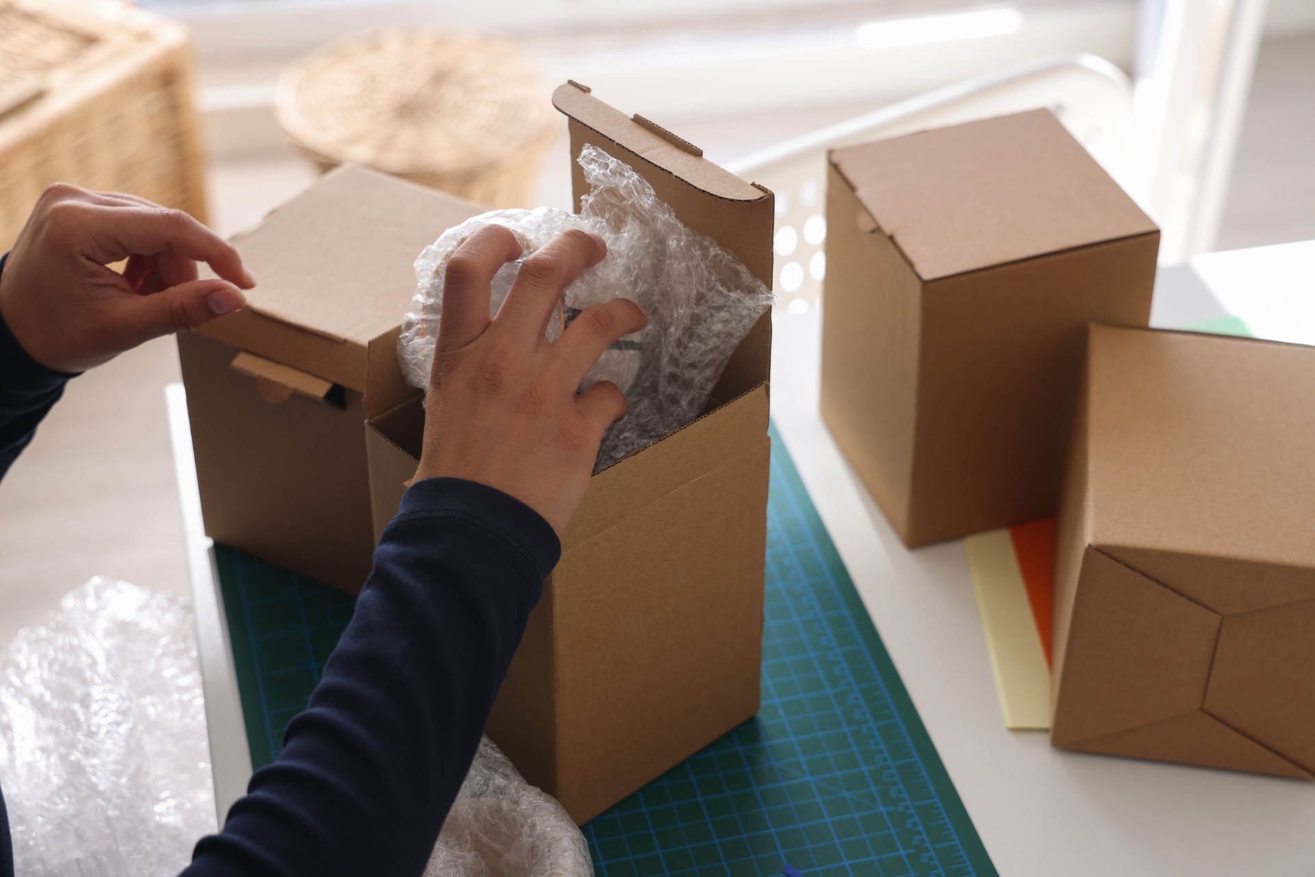 Woman covering ceramic with bubble wrap